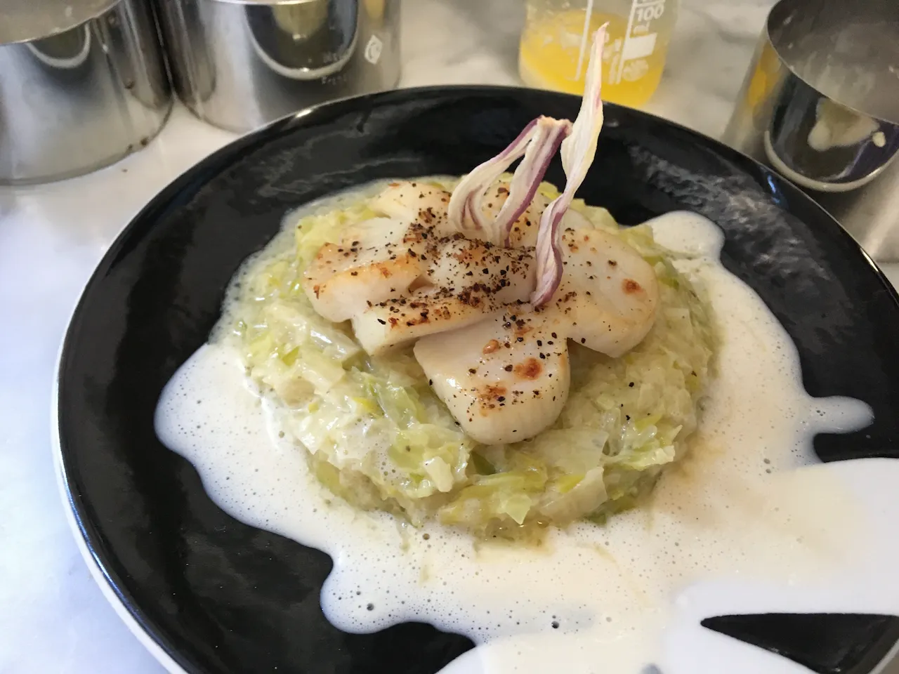 Saint-Jacques à la fondue de poireaux et pétales d'échalotes